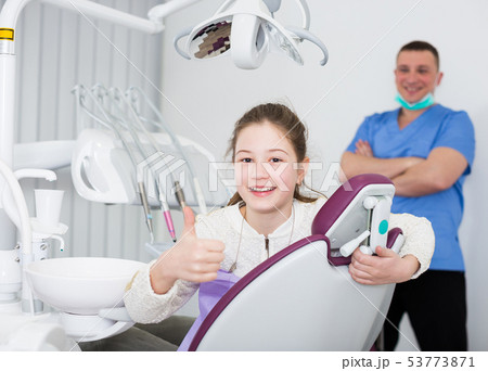 Girl patient in dental office showing ok gesture Girl patient in dental office showing ok gesture 53773871