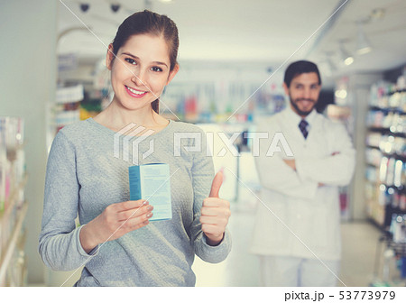 Smiling female client is satisfied of recommended medicine in apothecary. Smiling female client is satisfied of recommended medicine in apothecary. 53773979