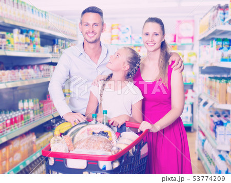 Portrait of customers which is standing with full trolley of goods 53774209