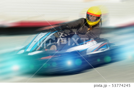 Girl driving kart at racing track outdoors 53774245