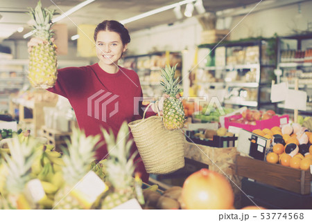Beautiful girl choosing ananas at market 53774568