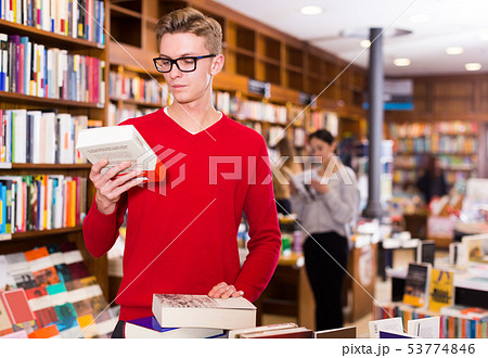 guy with stack of books in hands 53774846