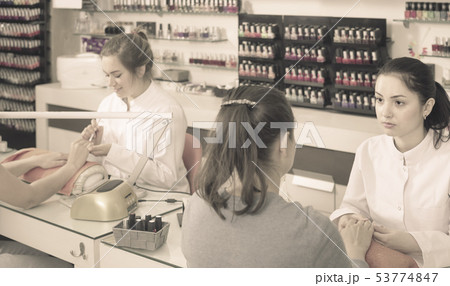 nail technicians performing manicure procedure in beauty salon 53774847