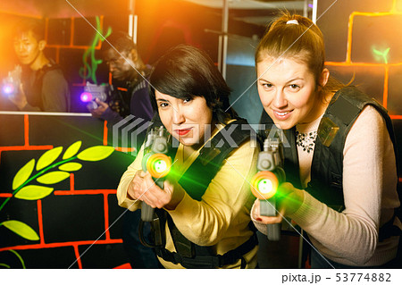 two emotional female laser tag players having fun in multination 53774882