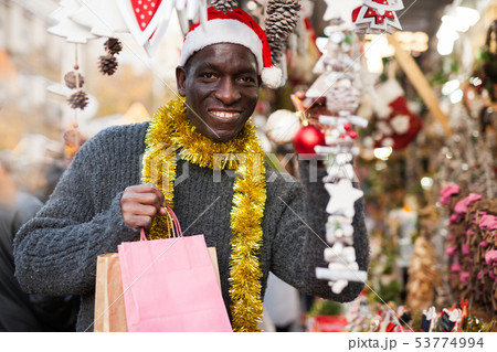 Laughing guy in Santa hat after Christmas shopping 53774994