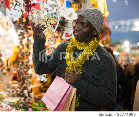 Man looking for New Year decorations Man looking for New Year decorations 53774999