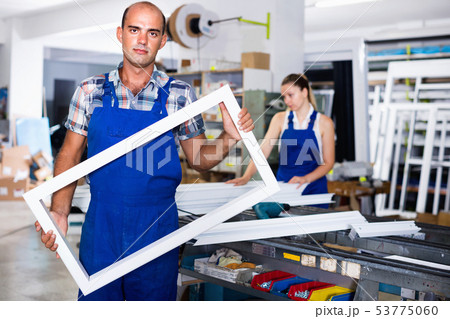Portrait of experienced male worker with plastic window frame 53775060