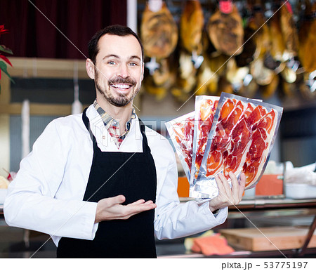 Male shop assistant demonstrating sliced bacon in butcher’s shop Male shop assistant demonstrating sliced bacon in butcher’s shop 53775197