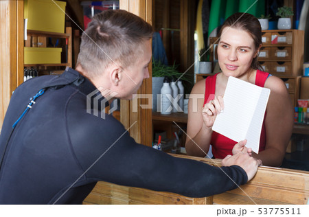Athletic man talking to girl at reception 53775511
