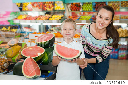 Portrait of happy woman and her little son choosing watermelon at shop 53775610