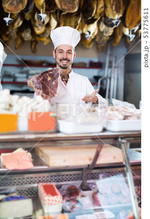 Seller showing piece of meat in butcher’s store 53775611