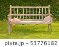 Ancient wooden bench in a garden with two straw 53776182