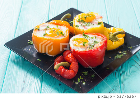 Baked pepper stuffed with bacon and eggs Baked pepper stuffed with bacon and eggs 53776267