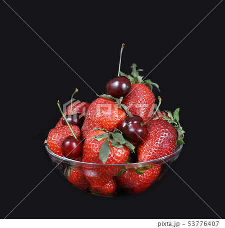 Glass bowl with ripe strawberries and cherries on  53776407
