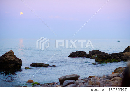 sea landscape at sunset with moon, stone coast and sea landscape at sunset with moon, stone coast and 53776597