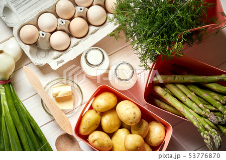 Fresh asparagus potatoes and eggs on white kitchen table Fresh asparagus potatoes and eggs on white kitchen table 53776870