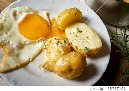 close up on fried eggs with young potatoes with butter and dill 53777101