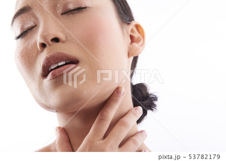 Calm woman having her eyes closed and touching her neck 53782179