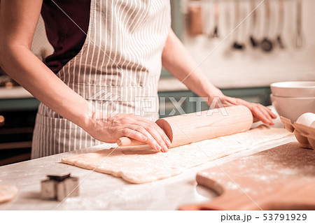 Young female person holding rolling pin in hands Young female person holding rolling pin in hands 53791929