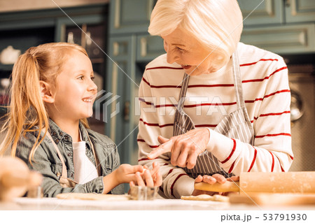 Positive delighted girl listening to her granny Positive delighted girl listening to her granny 53791930