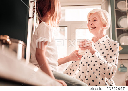 Kind granny looking at her granddaughter with love Kind granny looking at her granddaughter with love 53792067