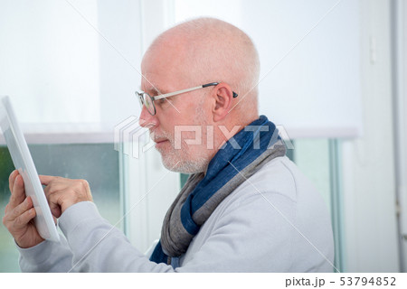 mature man using digital tablet at home mature man using digital tablet at home 53794852