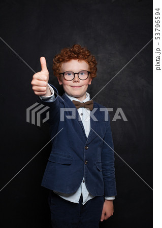 Happy child boy showing thumb up on chalkboard Happy child boy showing thumb up on chalkboard 53796594