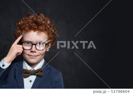 Smart child thinking on blackboard background. Smart child thinking on blackboard background. 53796604