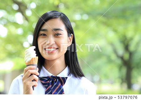 ソフトクリームを食べる女子高生の写真素材