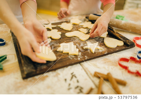 Little girls chefs spread out cookies on board 53797536