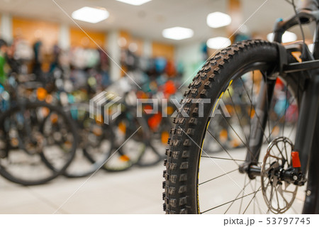 Bicycle in sports shop, focus on front wheel Bicycle in sports shop, focus on front wheel 53797745
