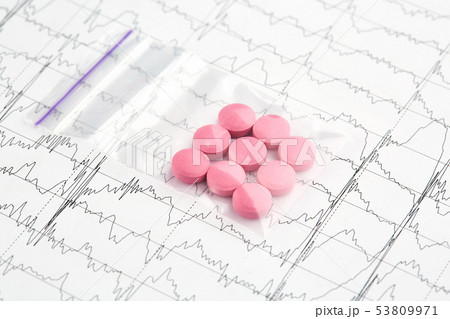 Pink pills in plastic bag on EKG graph Pink pills in plastic bag on EKG graph 53809971
