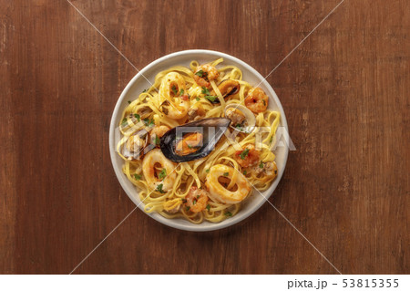 Seafood pasta. A plate of tagliolini with mussels, shrimps, clams and squid rings, shot from the top 53815355