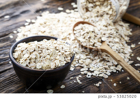 Spoon and bowl with raw oatmeal on the table. Top Spoon and bowl with raw oatmeal on the table. Top 53825020