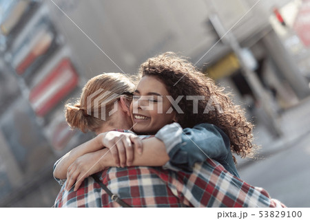 Joyful girl is meeting beloved man in city 53829100