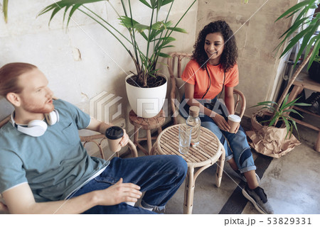 Young cheerful man and woman are relaxing in cafeteria 53829331