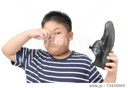 Disgusted boy holding a pair of smelly leather Disgusted boy holding a pair of smelly leather 53830060