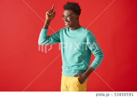 Happy Afro American guy in glasses posing on red background 53830591