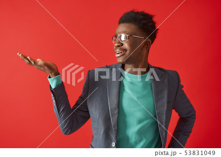 Smiling Afro American man is posing on red background Smiling Afro American man is posing on red background 53831049