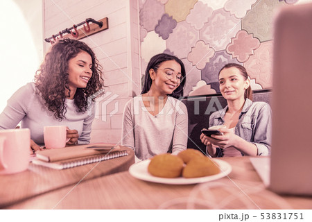 Three young mother meeting in cafeteria eating biscuits and drinking tea Three young mother meeting in cafeteria eating biscuits and drinking tea 53831751