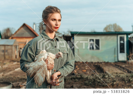 beautiful woman with a chicken in her hands 53833826