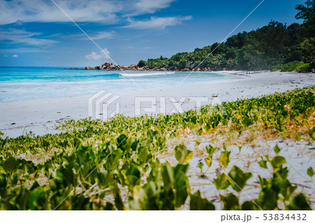 Low angle shot of remote Anse Coco beach, La Digue Island, Seychelles. Pristine blue crystal clear Low angle shot of remote Anse Coco beach, La Digue Island, Seychelles. Pristine blue crystal clear 53834432