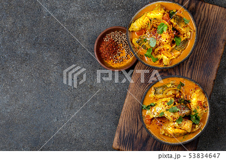 INDIAN FOOD. Traditional KERALA FISH CURRY with naan bread, gray plate, black background INDIAN FOOD. Traditional KERALA FISH CURRY with naan bread, gray plate, black background 53834647