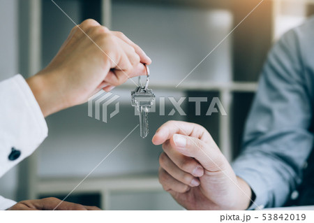 Close up hand of home agents are handing out keys 53842019