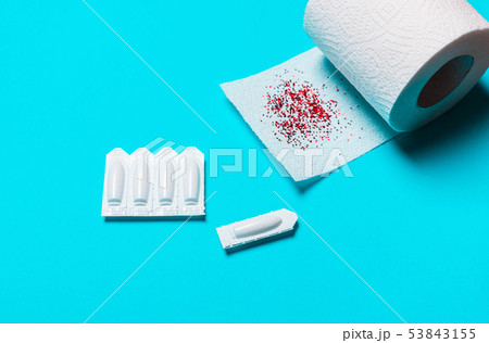 toilet paper and suppository on a blue background 53843155