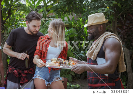 Smiling chef give barbecue to friend for dinner 53843834