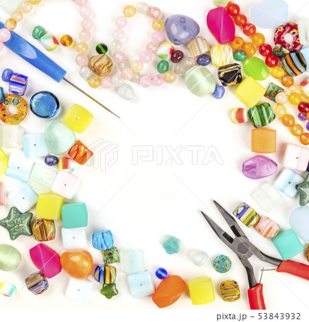 A square photo of beads with tools for making jewelry, shot from above on a white background with A square photo of beads with tools for making jewelry, shot from above on a white background with 53843932