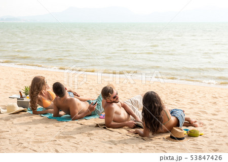 Friends lying at the beach taking a sunbath 53847426