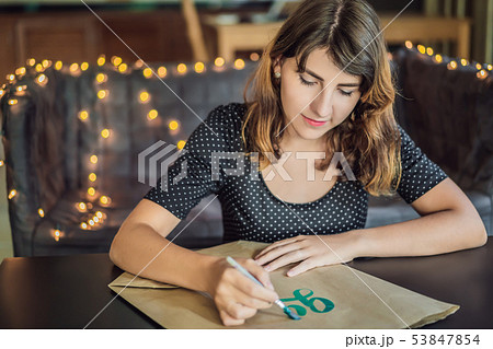 Go green. Calligrapher Young Woman writes phrase on white paper. Inscribing ornamental decorated 53847854
