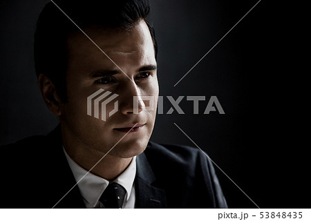 Man in shadow with serious face  53848435